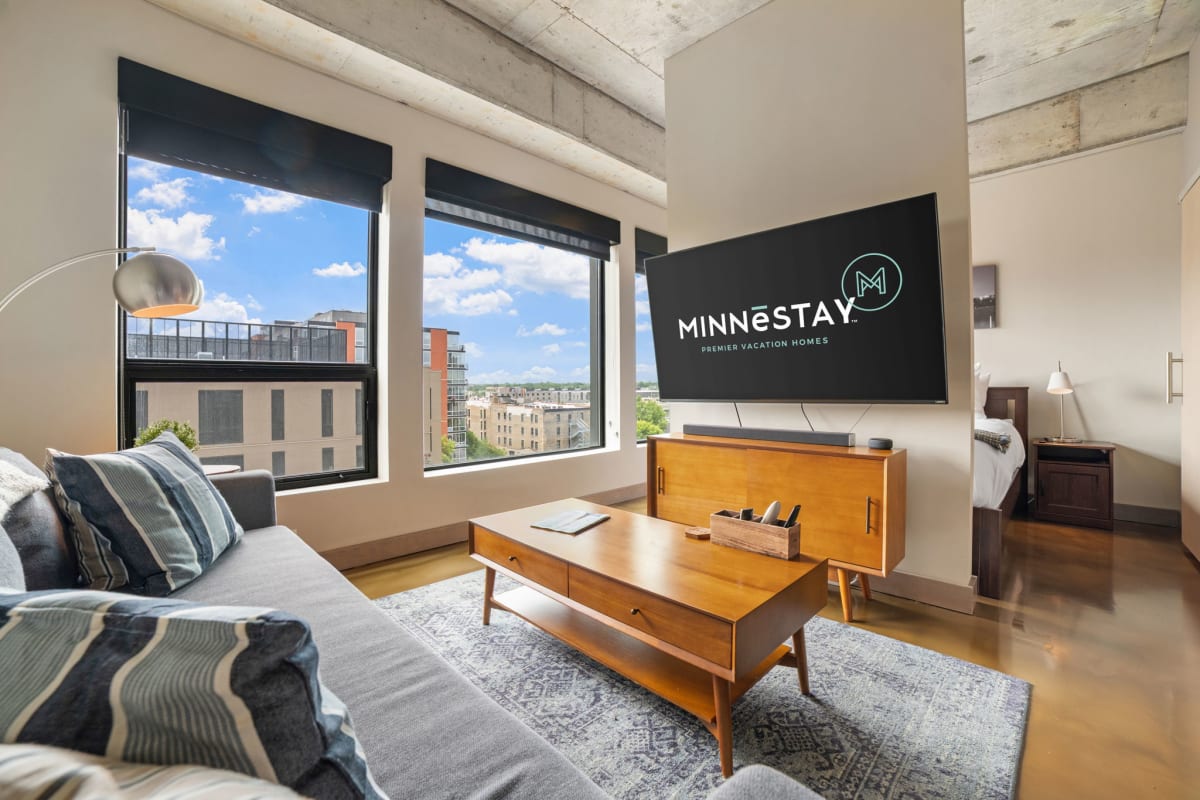 Unwind in your stylish living space with sweeping city views and warm mid-century furnishings that invite relaxation.