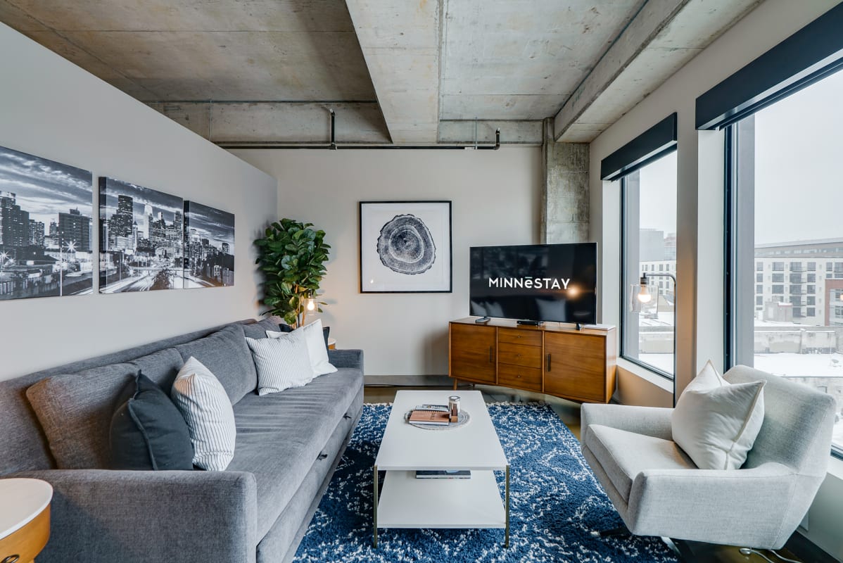 Unwind in your stylish living space with floor-to-ceiling windows showcasing stunning city views and modern industrial charm.