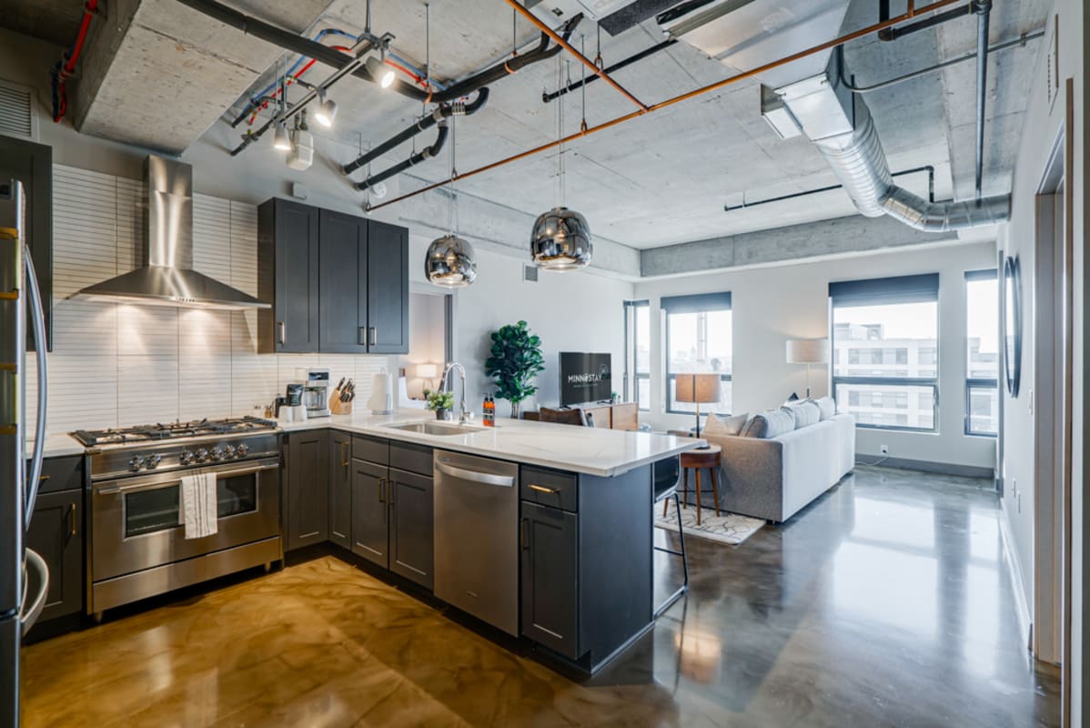 Your stylish loft features an open-concept kitchen with sleek appliances and bright city views through expansive windows.