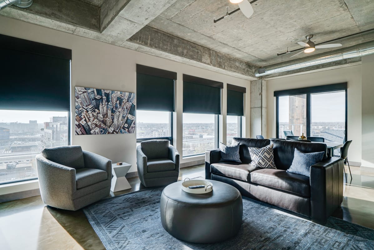 Unwind in your industrial-chic living room with panoramic city views and modern comfort.