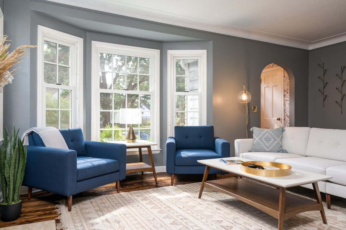 Sink into plush seating by bay windows where natural light fills your stylish living room retreat.