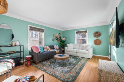 Cozy living room with mint green walls and colorful decorative elements.