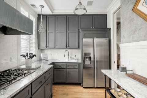 Kitchen featuring gray cabinetry, marble countertops, and stainless steel appliances.