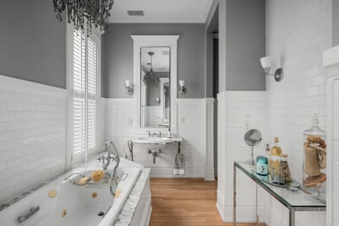 Sophisticated bathroom featuring a soaking tub, marble surfaces, and classic white subway tiles.