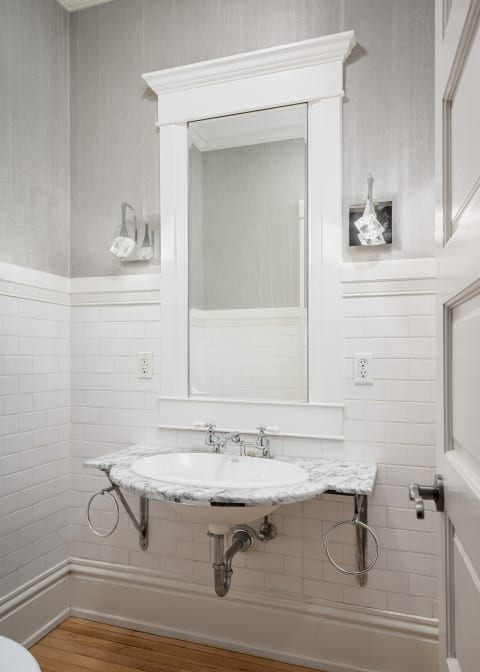 Elegant bathroom featuring a marble vanity and white subway tiles.