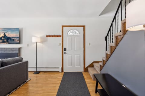 A modern entryway with wooden floors, a staircase, and contemporary decor.