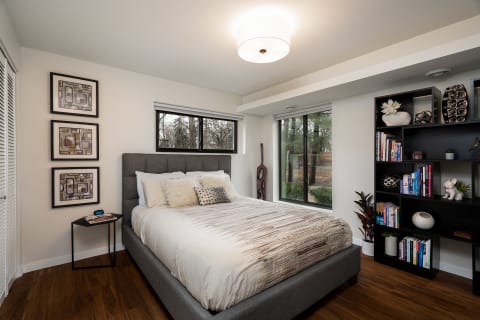 Modern bedroom featuring a plush bed, stylish decor, and large windows with a view.