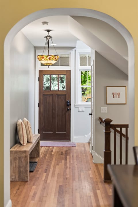 A cozy entryway featuring hardwood floors and a charming stained-glass light pendant.