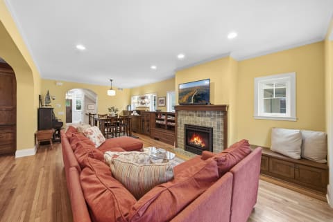 Cozy living room with plush seating, a fireplace, and yellow walls.