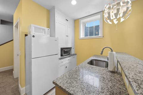 A bright kitchen with yellow walls, modern appliances, and a granite countertop.