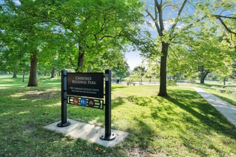 Cherokee Regional Park entrance sign with green trees and a pathway.