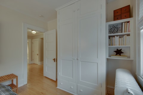 Cozy bedroom corner featuring built-in storage and decorative shelves filled with books and items.