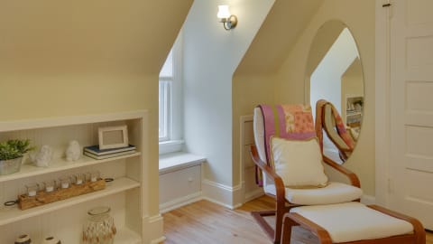 A cozy reading nook with an armchair, built-in shelving, and natural light.