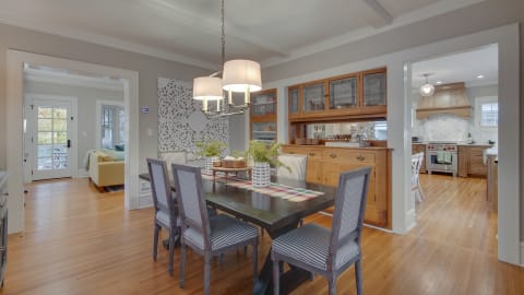 Elegant dining area featuring a dark wooden table, striped chairs, and stylish decor.