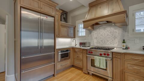 Modern kitchen with stainless steel appliances and wood cabinetry.