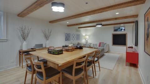 Spacious dining area with wooden beams, large table, and comfortable seating.
