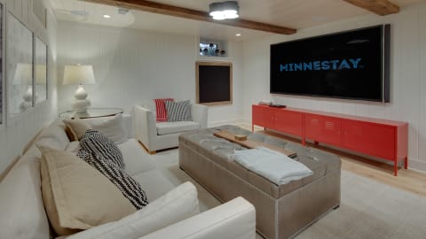 Cozy living room with a large TV and red media console