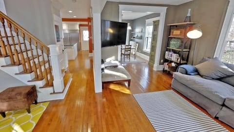 Interior view of a stylish entryway transitioning into a cozy living room and kitchen area.