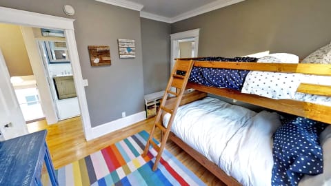 A cheerful bunk room with polka dot bedding and colorful rugs, perfect for kids.