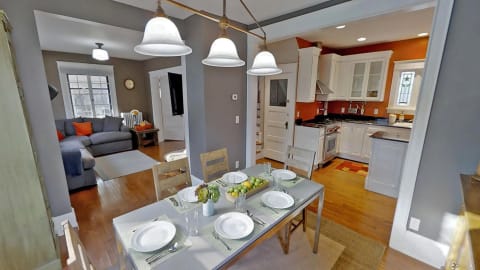 Cozy dining area with a table set for dinner and a view into a living room and kitchen.