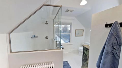 Modern bathroom featuring a walk-in shower and natural light through a window.