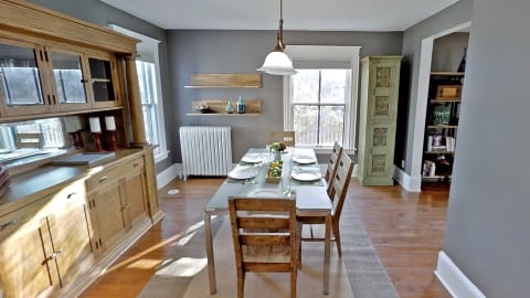 Elegant dining space featuring a wooden table set for dinner surrounded by rustic chairs.