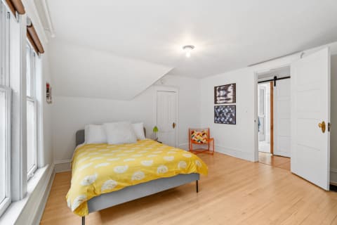 A cozy bedroom with yellow bedding, natural light, and stylish furniture.