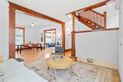 Open-concept living space with wooden beams, hardwood floors, and modern furniture.