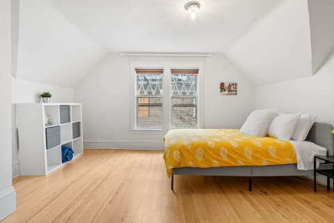 Bright bedroom with yellow bedding, warm wood floors, and cheerful decor.