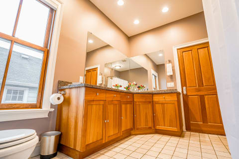 Elegant bathroom featuring wood vanity and granite countertop with ambient lighting.