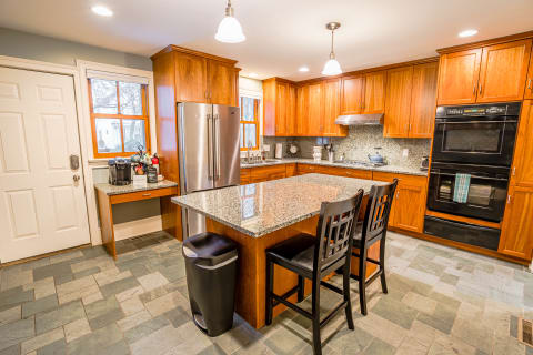 Gourmet kitchen with granite countertops, modern appliances, and breakfast island.