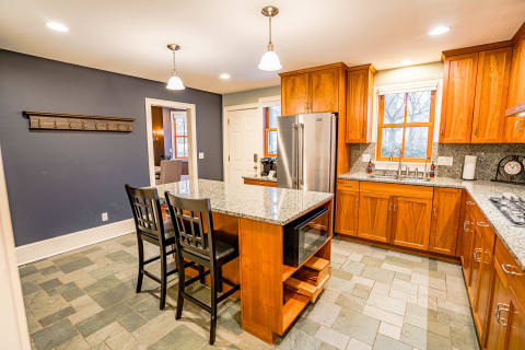 A gourmet kitchen showcasing wood cabinets, granite counters, and a large central island.