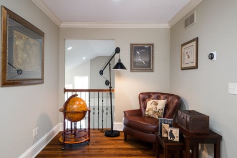 A cozy nook with a leather chair, globe, and decorative artwork on the walls.