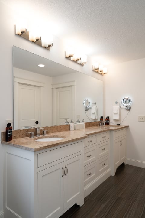 Modern bathroom with a spacious vanity, textured countertop, and bright lighting.