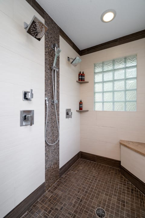Contemporary shower with multiple fixtures and calming design elements.