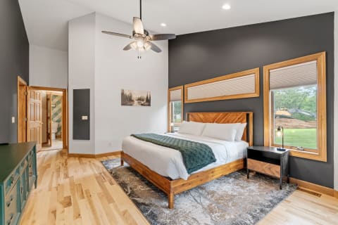 Stylish bedroom featuring a king-size bed, wooden decor, and natural light.