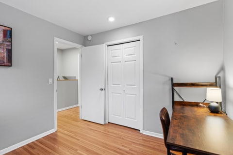 Stylish minimalist room with a wooden desk, chair, and warm lighting.