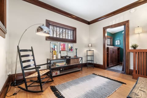 Cozy living room featuring a rocking chair, lamp, and decorative elements.