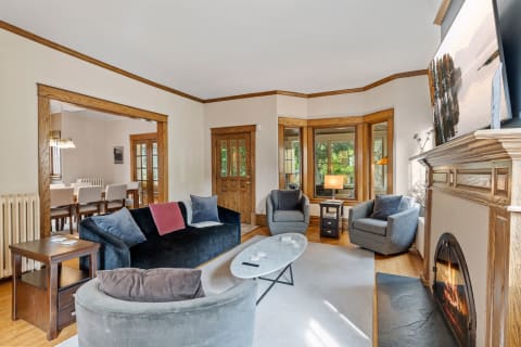Interior view of a cozy living room with a blue couch and gray armchairs.