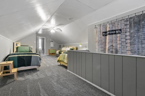 Loft-style bedroom featuring two beds, grey walls, and a whimsical platform theme.