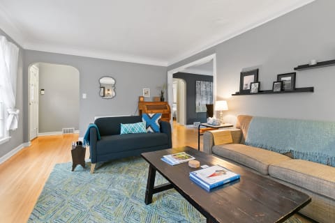 Cozy living room featuring gray walls, comfortable sofas, and a wooden coffee table.