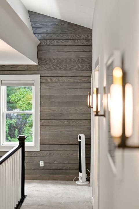 A modern stairway with wooden paneling and natural light illuminating the space.