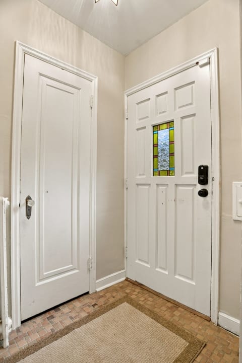 Inviting entrance with white door and stained glass accents