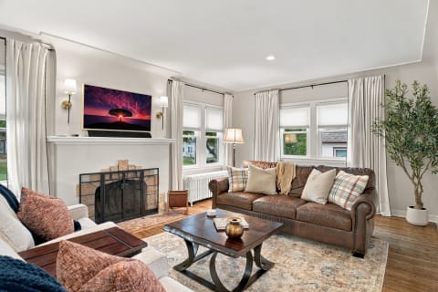 Cozy living room with leather sofa, coffee table, and decorative cushions.