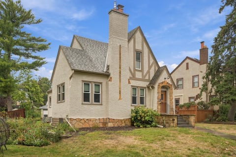 A Tudor-style home with beautiful stone accents and lush garden.