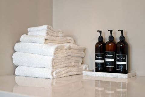 Neatly stacked towels and premium toiletries in a bathroom setting, exuding a tranquil atmosphere.