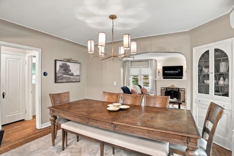 A cozy dining room with elegant wooden furniture and a chandelier, overflowing with warmth and style.