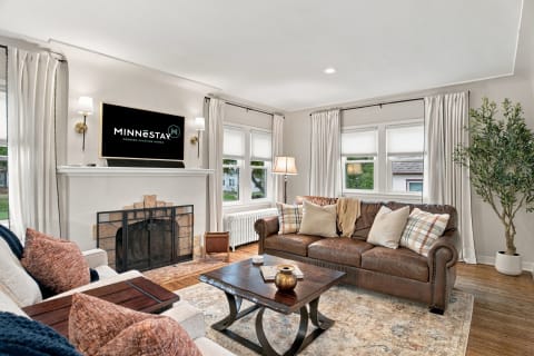 Cozy living room with leather sofa, rustic coffee table, and natural light.