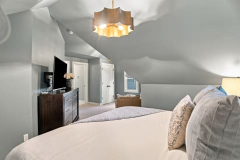 Cozy bedroom with vaulted ceiling, calming colors, and plush bedding.