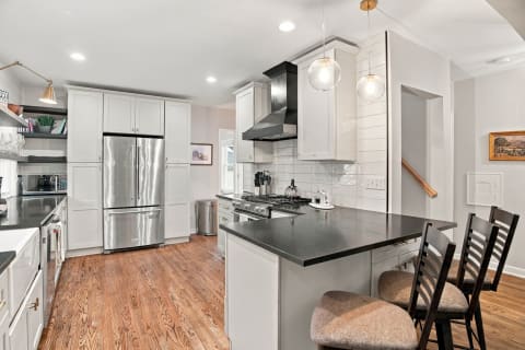 Modern kitchen with stainless steel appliances, sleek countertops, and a spacious island with bar stools.